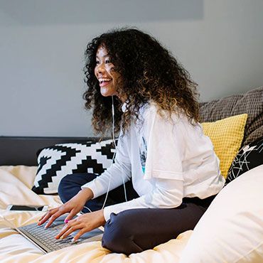 Female student working on laptop in accommodation room