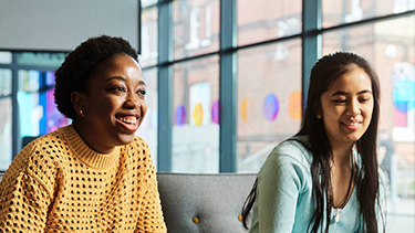 Two female students talking and smiling