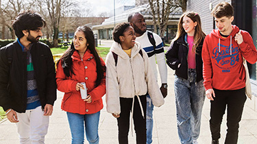 Students group walking and smiling on the campus
