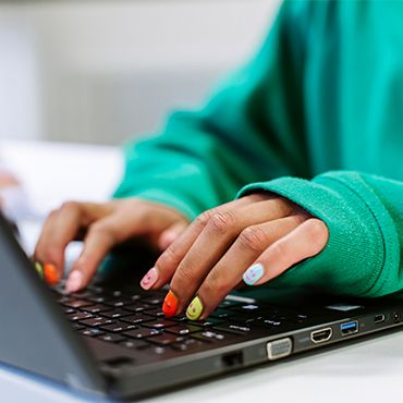 Student typing on the laptop